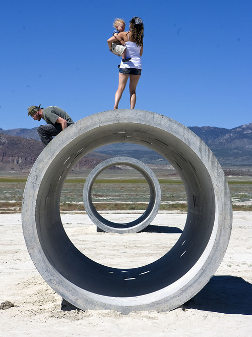 Al Hartmann  |  The Salt Lake Tribune

Tara Thornely holds her son Tama Gaia, 3, and takes in the view of the desert as her husband, Mathu Gaia, hops down from the Sun Tunnels on Tuesday near Lucin.