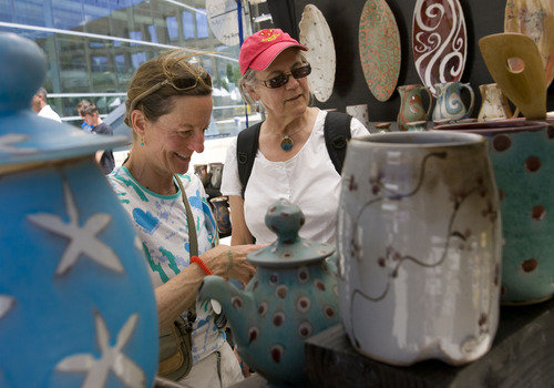 Al Hartmann  |  The Salt Lake Tribune
Polly Harris, left, and Bee Lufkin admire some of the pottery made by independent studio artist Brad Henry of Truckee, Calif., during the opening hours of the Utah Arts Festival in Salt Lake City on Thursday.