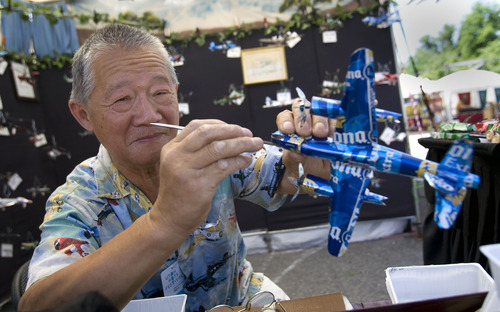 Al Hartmann  |  The Salt Lake Tribune
Shao Lin Xia, a retired Boeing aeronautics engineer from Granite Falls, N.C., makes a B-26 Martin airplane to scale with pieces of a Corona beer can during the opening hour of the Utah Arts Festival in Salt Lake City on Thursday. It continues through Sunday.