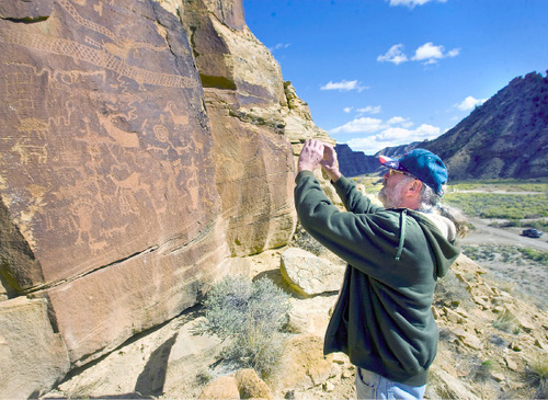 Al Hartmann  |  The Salt Lake Tribune
Jochen Lahman, a tourist from Bergdorf, Germany, takes a picture of a rock art panel above the road in Nine Mile Canyon. He  started coming to the canyon to look at the rock art 25 years ago.