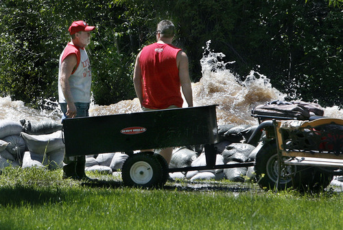 Scott Sommerdorf  |  The Salt Lake Tribune
Rob Taylor, left, and his son-in-law, Nick Funcannon, survey the Weber River's whitewater rapids on Saturday as they take a breather from sandbagging against the torrent.