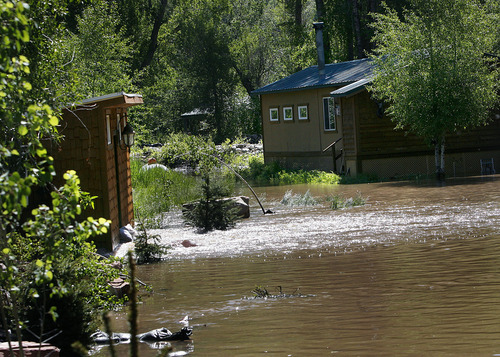 Scott Sommerdorf  |  The Salt Lake Tribune
Floodwater pours through Scott Quai's shed (left) and around his summer home Saturday in the Pinion Lane neighborhood near the mouth of Weber Canyon, east of Oakley.