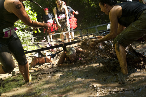 Photo by Chris Detrick | The Salt Lake Tribune 
Women craw through mud during the Kiss Me Dirty Race Series at Wheeler Historic Farm Saturday July 2, 2011.  The four-mile obstacle mud course, was run only by women, who were raising money for gynecological cancer research.