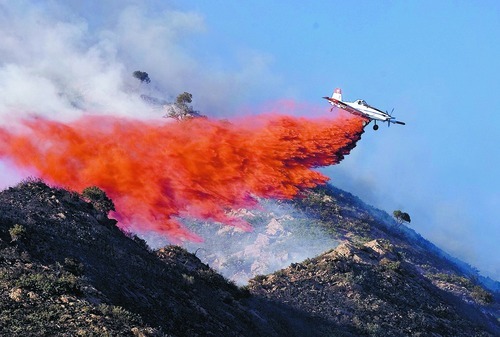 Djamila Grossman  |  The Salt Lake Tribune

A plane drops retardant on flames as a wildfire burns in the hills above the University of Utah Research Park in Salt Lake City, Utah, on Sunday, July 3, 2011.