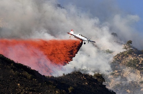 Djamila Grossman  |  The Salt Lake Tribune

A plane drops retardant on flames as a wildfire burns in the hills above the University of Utah Research Park in Salt Lake City, Utah, on Sunday, July 3, 2011.