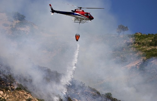 Djamila Grossman  |  The Salt Lake Tribune

A helicopter drops water on flames of a wildfire that burns in the hills above Red Butte Garden and the new Utah Museum of Natural History in Salt Lake City, Utah, on Sunday, July 3, 2011.