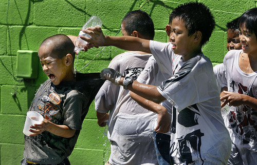 Scott Sommerdorf  |  The Salt Lake Tribune
Water soaked boys watch as Mu Khai (13), puts water down the neck of his friend Morna Ka (8), left, Sunday, July 3, 2011. One of the traditions at the annual Thingyan (Water) festival is to mingle through the crowd and douse people with water. The fesival celebrates New Year, that is actually in April, but since the Utah weather is so cold, it is delayed until July each year.