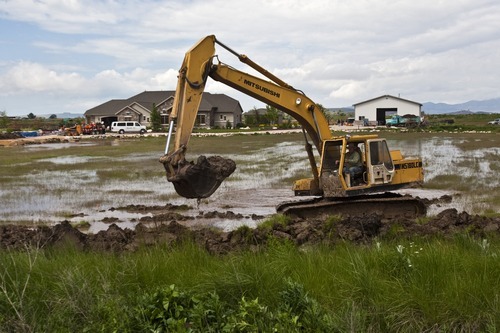 Chris Detrick  |  The Salt Lake Tribune 
Gary Nielsen works in front of his flooding property in West Warren on June 9.