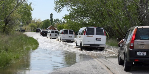 Steve Griffin  |  The Salt Lake Tribune
Weber County sheriff vans carrying lawmakers and media members follow an SUV carrying Utah Gov. Gary Herbert as they drive through flood-covered streets during a tour of flooded areas of Weber County on May 31.