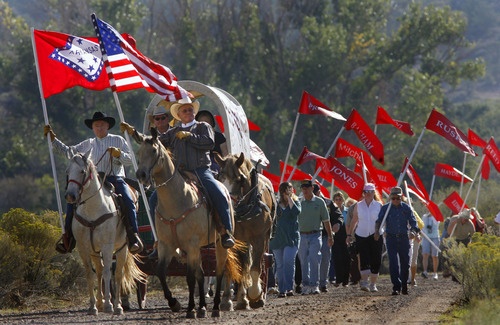 Tribune file photo
Descendants of the victims of the Mountain Meadow Massacre carry flags with their family names on them as they are led down the road by the Fancher Wagon Train, to the Mountain Meadow Massacre Memorial Grave Site, during the Mountain Meadows Massacre Memorial near Enterprise in September 2007. The site has been named a national landmark.
