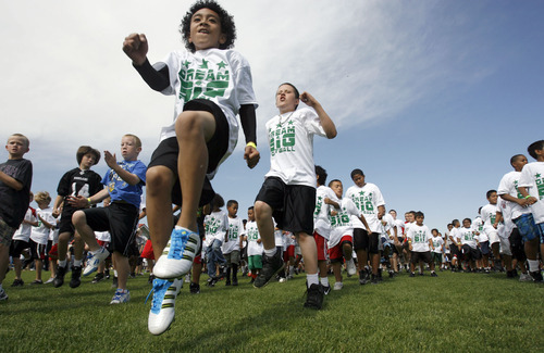 Francisco Kjolseth  |  The Salt Lake Tribune
Kingi Fisiipeau, 9, of Bluffdale kicks his knees up high as he warms up with hundreds of other kidsas part of former Ute and current member of NY Jets Sione Po'uha's youth football camp at East High on Thursday, June 30, 2011.