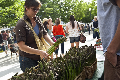 Chris Detrick  |  The Salt Lake Tribune 
Edible Wasatch's Rachel Hodson buys asparagus from Day Farm at the Downtown Farmers Market at Pioneer Park on June 18.