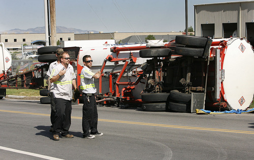 Scott Sommerdorf  |  The Salt Lake Tribune
Workers talk about how best to right a tanker that collided with a train on Center Street in North Salt Lake, Monday, July 11, 2011. The impact tipped over the rear tanker of the truck, which was empty.