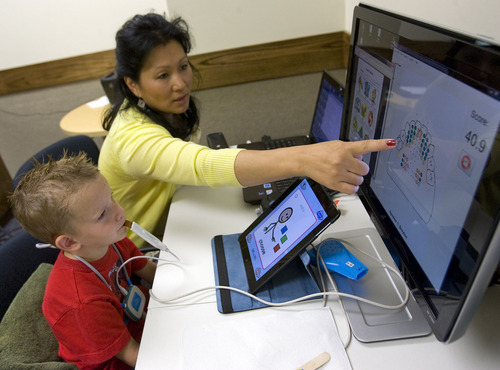 Al Hartmann  |  The Salt Lake Tribune
Five-year-old Breyton Banks uses a device called a palatometer in a speech therapy session with speech language pathologist Ann Dorais at the Comprehensive Clinic on BYU campus.   The custom-fit retainer allows therapists to use computers to watch precisely how kids pronounce words and help them correct their speech in real time.