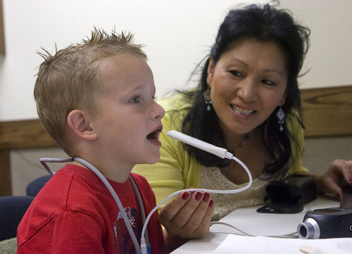 Al Hartmann  |  The Salt Lake Tribune
Five-year-old Breyton Banks uses a device called a palatometer in a speech therapy session with speech language pathologist Ann Dorais at the Comprehensive Clinic on BYU campus.   The custom-fit retainer allows therapists to use computers to watch precisely how kids pronounce words and help them correct their speech in real time.