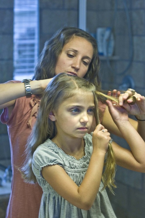 Paul Fraughton  |  The Salt Lake Tribune.
Mindy McKnight works on a hairstyle on her daughter.
