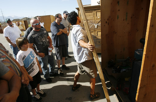 Francisco Kjolseth  |  The Salt Lake Tribune
People gather around as one of six storage units is cracked open by Josh Young before people decide to bid on whatever items may be found inside during a recent auctions at A-1 Pioneer Storage in North Salt Lake on July 2. The belongings of someone who has defaulted on their storage units could contain valuable items or things bound for the dump as people are only allowed to peek in and take a gamble on the value of what they can see.