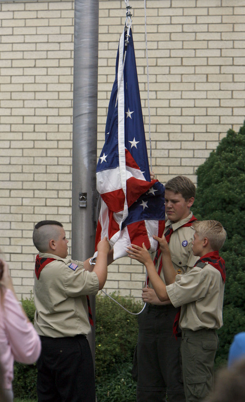Francisco Kjolseth  |  The Salt Lake Tribune
Scouts raise the flag in honor of David Rayborn, 12, at the Granite Park Stake Center in Salt Lake City on Tuesday. Rayborn was struck and killed by lightning on July 13 during a weeklong Boy Scout camp at Scofield Reservoir.