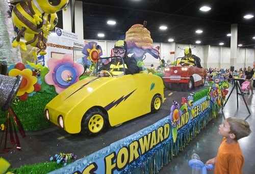 Paul Fraughton  |  The Salt Lake Tribune
Jacob Stanger, 6 of Herriman,  watches as Ashlyn Peterson, 17, dressed as a bee, drives a race car on the West Jordan River Oaks Stake float. The float was among other Days of '47 Parade entries on display at the South Towne Expo Center on  Wednesday,  July 20, 2011.