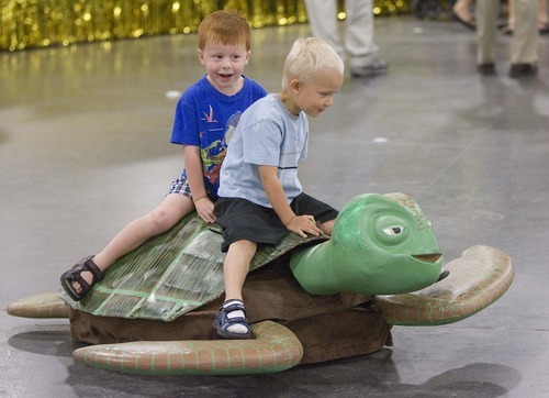 Paul Fraughton  |  The Salt Lake Tribune
Paul Meldrum (4) and Gus Cooper (4)  take a ride on a radio-controlled sea turtle that was part of the Bennion West Stake's float on display at the South Towne Expo Center on  Wednesday,  July 20, 2011.