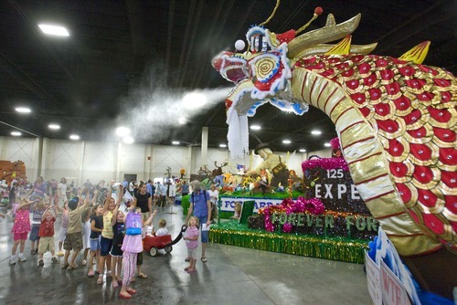 Paul Fraughton  |  The Salt Lake Tribune 
Children dance beneath  the cooling spray mist  of a  dragon, which is part of a float sponsored by the Chinese Society of Utah. The float was among other Days of '47 Parade entries on display at the South Towne Expo Center on  Wednesday,  July 20, 2011.