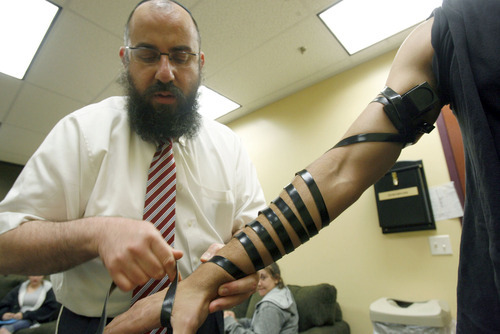 Francisco Kjolseth  |  The Salt Lake Tribune
Rabbi Benny Zippel wraps the arm of  Netanel Kabaci, 16, in a Jewish ritual known as 