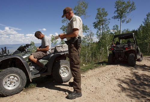 Trent Nelson  |  The Salt Lake Tribune
Ranger Drew Patterson cites Jeff Huntsman for an expired registration while patrolling Wasatch Mountain State Park in Midway on Saturday, July 2, 2011.
