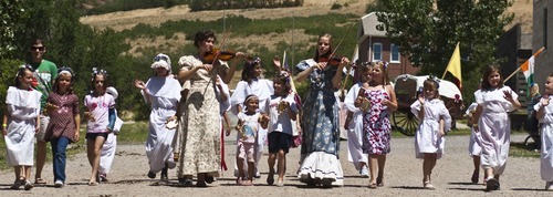 Chris Detrick | The Salt Lake Tribune 
Violinists Phoebe Romney and Mary-Martha Jackson participate in the Village Parade walk along Main Street during Pioneer Days Festival at This Is the Place Heritage Park Saturday July 23, 2011.