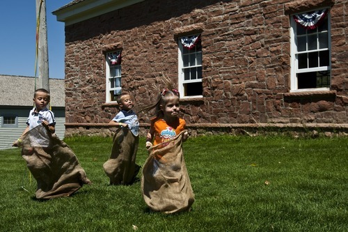 Chris Detrick | The Salt Lake Tribune 
Nathan Croxford, 5, Joshua Croxford, 5, and Hallie Croxford, 4, jump during a sack race during Pioneer Days Festival at This Is the Place Heritage Park Saturday July 23, 2011.