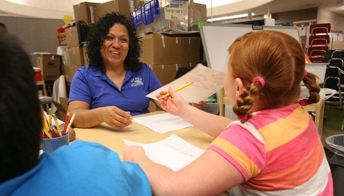 Leah Hogsten  |  The Salt Lake Tribune
Dee Elementary School third-grade teacher Elida Henriquez helps her summer school students with their short autobiographies Wednesday, July 20 2011 in Ogden.