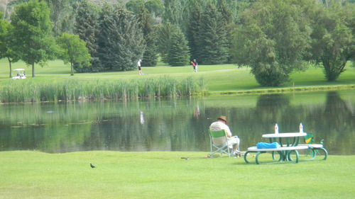 Tom Wharton | The Salt Lake Tribune
Daniel Robison of Heber enjoys a morning of fishing at a pond
at Wasatch Mountain State Park, while golfers take in a round on the nearby course.