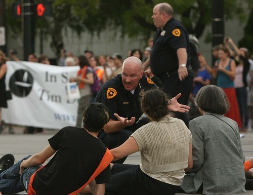 Leah Hogsten  |  The Salt Lake Tribune
Salt Lake City Police Chief Chris Burbank explains the arrest procedure to protesters sitting in the middle of the intersection of  400 South and Main Street. Police arrested 26 people during a demonstration that blocked traffic along Main Street near the federal courthouse July 26 in Salt Lake City.