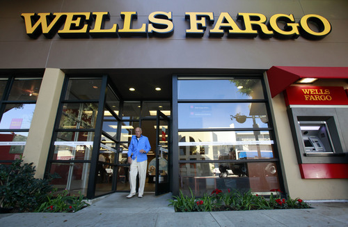 FILE - In this Jan. 18, 2011 file photo, a customer exits a Wells Fargo bank branch in Los Angeles. Wells Fargo & Co. said Tuesday, July 19, 2011, its second-quarter profit rose 30 percent, boosted by a release of reserves set aside to cover souring loans as its customers continued to improve their loan and credit card payments. (AP Photo/Reed Saxon, file)