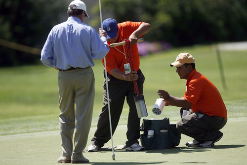 Francisco Kjolseth  |  The Salt Lake Tribune
Rules official Vaughn Moise holds the flag for the par 3, hole 7 at the Willow Creek Golf Course as Israel Perez, center, with 14-years experience as grounds keeper swaps out a damaged hole with a new cup with the help of his brother Osiel. The Nationwide Tour, the Triple-A of the PGA Tour, makes its stop at the Willow Creek Country Club in Sandy on Thursday, July 28, 2011, for the first of four days.