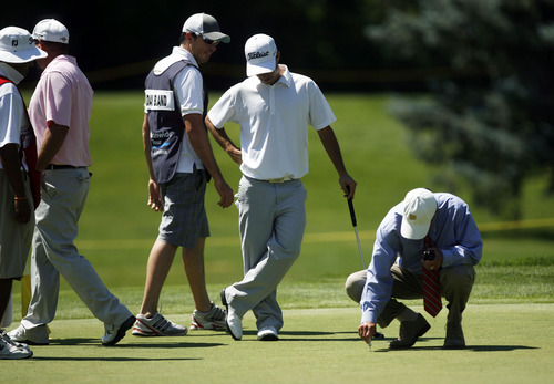 Francisco Kjolseth  |  The Salt Lake Tribune
Rules official Vaughn Moise makes a temporary fix on hole 7, after John Kimbell of San Antonio, TX, nearly got a hole in one on the par 3 after his ball bounced a couple inches from the hole and hit the flag. The Nationwide Tour, the Triple-A of the PGA Tour, makes its stop at the Willow Creek Country Club in Sandy on Thursday, July 28, 2011, for the first of four days.