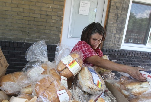 Rick Egan   |  The Salt Lake Tribune

Kathy Hills, of Rose Park, gathers food from Shauna Devenport's front porch, Thursday, July 28, 2011. Devenport, the Bread Lady, has been distributing day-old bread, shoes and clothes from her front porch in Salt Lake City for nearly 20 years. She collects food from grocery stores and bakeries around the city, and gives it away to those in need from her front porch.
