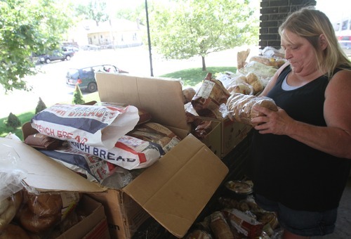 Rick Egan   |  The Salt Lake Tribune

Carrie Christensen, gathers food from Shauna Devenport's front porch, Thursday, July 28, 2011. Devenport, the Bread Lady, has been distributing day-old bread, shoes and clothes from her front porch in Salt Lake City for nearly 20 years.