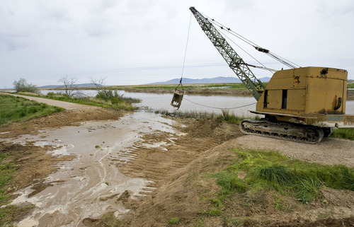 Al Hartmann  |  The Salt Lake Tribune
Drag line opens a breach in a dike road at the Ogden Bay Waterfowl Management Area west of Hooper May 26. The area was breached three times (one natural) to prevent flooding.