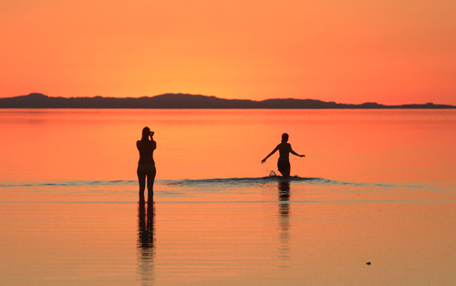 Rick Egan   |  The Salt Lake Tribune
Visitors wade in the Great Salt Lake at Antelope Island at sunset in 2010.