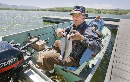 Paul Fraughton  |  The Salt Lake Tribune
Lee Johnson shows off his catch  from Hyrum Reservoir. He was fishing with his wife, Karen, and their dog Candy on June 28.