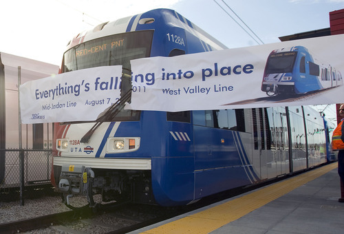 Al Hartmann  |  The Salt Lake Tribune
A new stepless TRAX train breaks through a banner to open the Daybreak Parkway Station during a pre-kickoff ceremony Tuesday at Daybreak. The train contiued on to West Valley City to open the West Valley Central Station at 3650 South 2800 West.