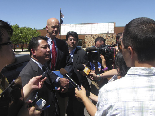 Attorneys for Yasushi Mikuni,  Garrett Ogata left and Keith Barnes in red tie are swarmed by members of Japanese news media outside 5th District Court in Cedar City on Friday after a sentencing hearing for Mikuni who pleaded guilty in June for  rolling a small bus that killed three Japanese tourists and injuring several others. Mark Havnes/The Salt Lake Tribune.