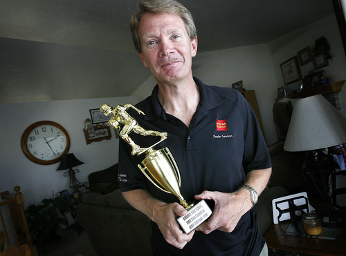 Scott Sommerdorf  |  The Salt Lake Tribune
Alan Alderman proudly holds the trophy won by his son Justin, who, as a senior won a state football championship while playing for Bingham. Alan also won a state football championship when he was a senior at Logan High. Alderman has ALS (Lou Gehrig's Disease). He is a single father and an advocate who travels to Washington, D.C., to beseech Congress for research funds. Photographed in his home in South Jordan, Monday, August 8, 2011.