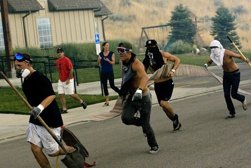 Djamila Grossman  |  The Salt Lake Tribune
Neighborhood youth run to volunteer as a wildfire burns in the hills above their homes in Draper, Utah, on Saturday. The fire threatened several homes but destroyed none.