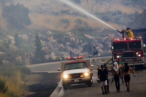 Djamila Grossman  |  The Salt Lake Tribune

A fire engine hoses down a hill side as a wildfire burns in the hills above Draper, Utah, on Saturday, Aug. 13, 2011. The fire threatened several homes but destroyed none.