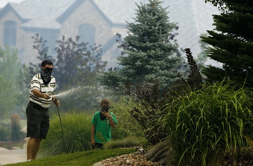 Djamila Grossman  |  The Salt Lake Tribune

Residents try to soak their lawn with water as a wildfire burns in the hills above their homes in Draper, Utah, on Saturday, Aug. 13, 2011. The fire threatened several homes but destroyed none.