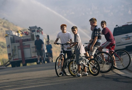 Djamila Grossman  |  The Salt Lake Tribune

Kids on bikes stand by as a fire burns in the hills above in Draper, Utah, on Saturday, Aug. 13, 2011. The fire threatened several homes but destroyed none.