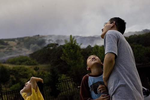 Djamila Grossman  |  The Salt Lake Tribune

Steve Liang and his sons Kevin, 11, and Andy, 10, watch as a helicopter drops water on a fire that burns above their homes in Draper, Utah, on Saturday, Aug. 13, 2011. The fire threatened several homes but destroyed none.