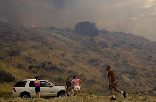 Djamila Grossman  |  The Salt Lake Tribune

Residents watch as a fire burns in the hills above their homes in Draper, Utah, on Saturday, Aug. 13, 2011. The fire threatened several homes but destroyed none.