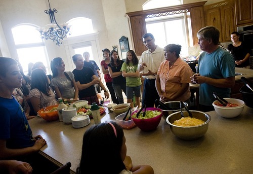 Djamila Grossman  |  The Salt Lake Tribune
Hosts Debbie and Jay Beauregard, right, their guests from Bulgaria and others stand in their kitchen after a short prayer in Bountiful on Aug. 7. This is the second year the Beauregards have been hosts for foreign visitors, including the 12 people from Bulgaria.